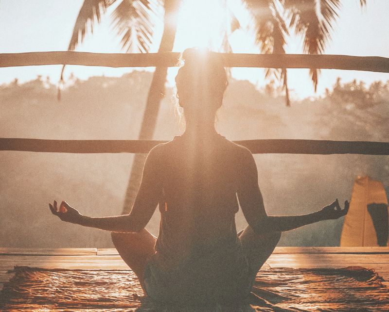 Jungbrunnen Retreat, hier Frau im Yogasitz, Farben der Abenddämmerung